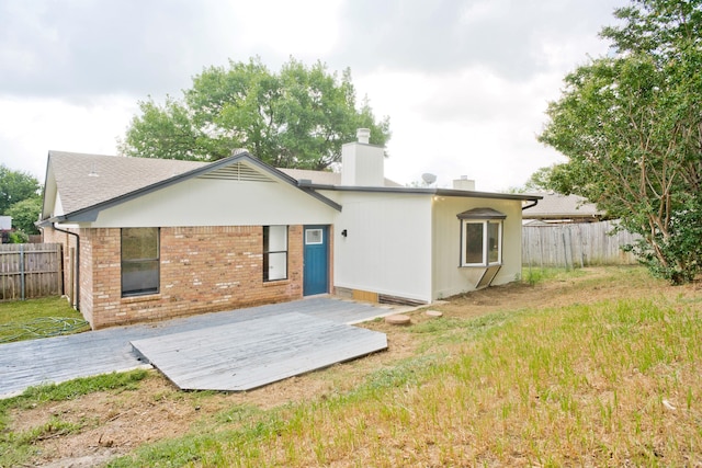 back of property featuring a yard and a deck