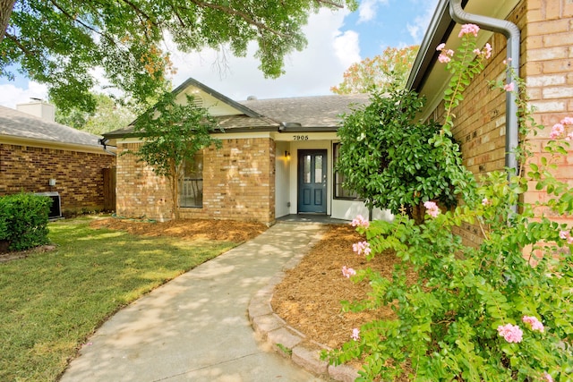 property entrance with a lawn