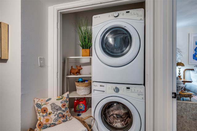 washroom featuring stacked washer and clothes dryer