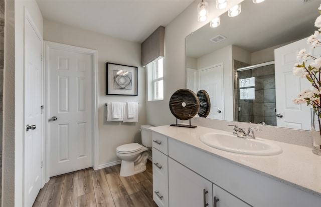 bathroom featuring vanity, hardwood / wood-style flooring, toilet, and an enclosed shower