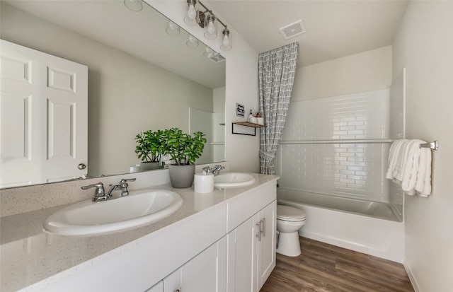 full bathroom featuring hardwood / wood-style floors, vanity, toilet, and shower / washtub combination