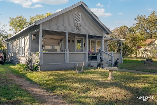 bungalow-style home featuring covered porch and a front yard