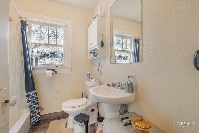 full bathroom with sink, wood-type flooring, shower / bath combination with curtain, and toilet