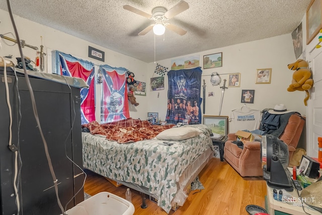 bedroom featuring ceiling fan, wood-type flooring, and a textured ceiling