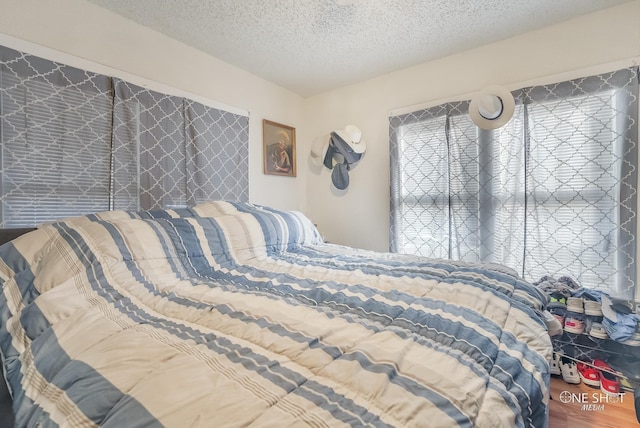 bedroom with a textured ceiling and hardwood / wood-style flooring