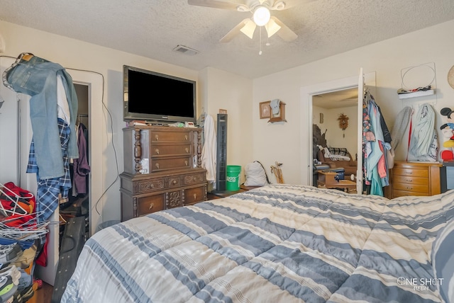 bedroom with ceiling fan and a textured ceiling