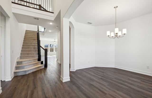 interior space featuring ceiling fan with notable chandelier and dark wood-type flooring