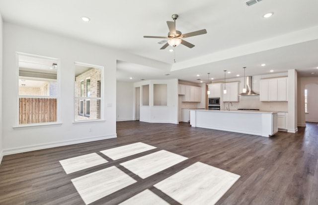 unfurnished living room featuring ceiling fan, sink, and dark hardwood / wood-style floors