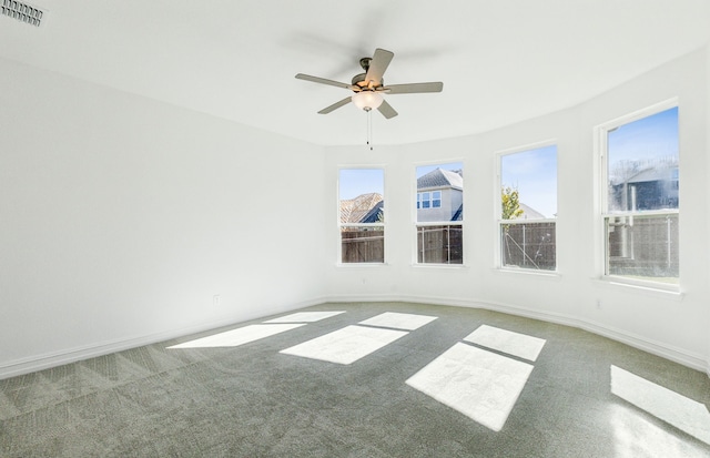 carpeted spare room featuring ceiling fan