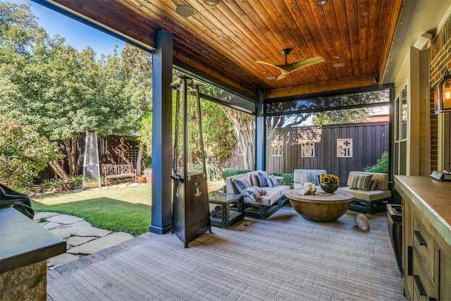 sunroom featuring ceiling fan and wood ceiling