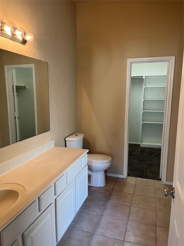 bathroom with toilet, tile patterned floors, and vanity