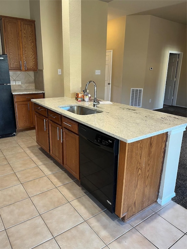 kitchen featuring sink, light tile patterned floors, and black appliances