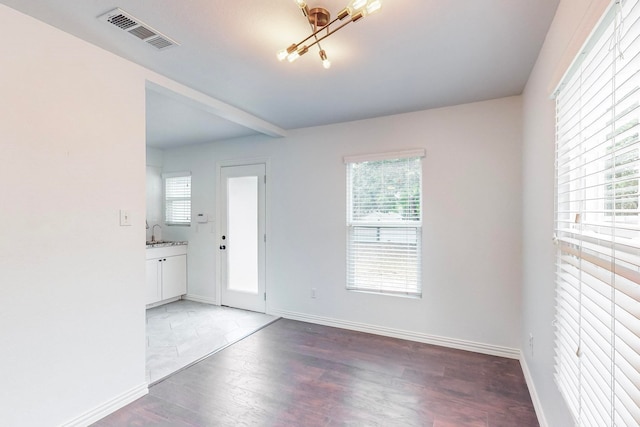 foyer entrance featuring hardwood / wood-style flooring, a chandelier, and plenty of natural light