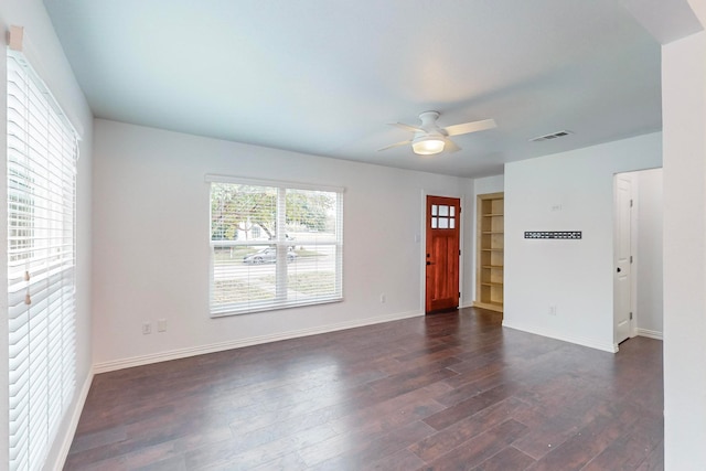 unfurnished room featuring dark wood-type flooring and ceiling fan