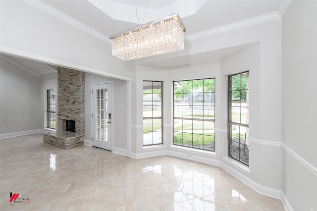 unfurnished living room featuring plenty of natural light, a large fireplace, and crown molding