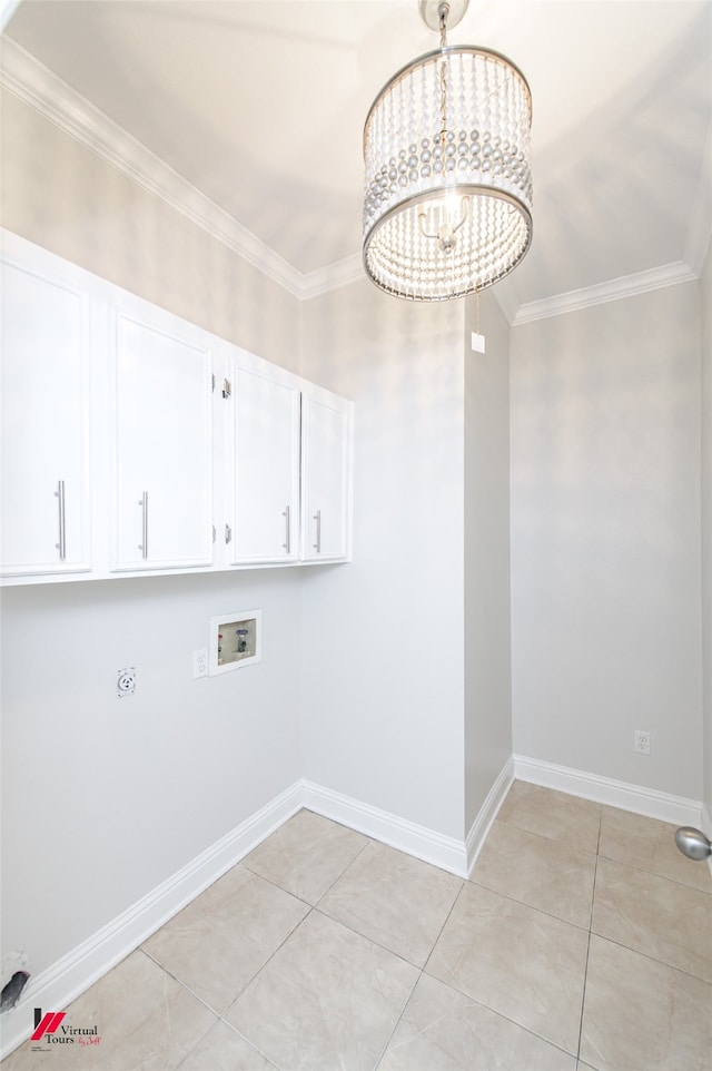 washroom featuring washer hookup, cabinets, an inviting chandelier, and ornamental molding