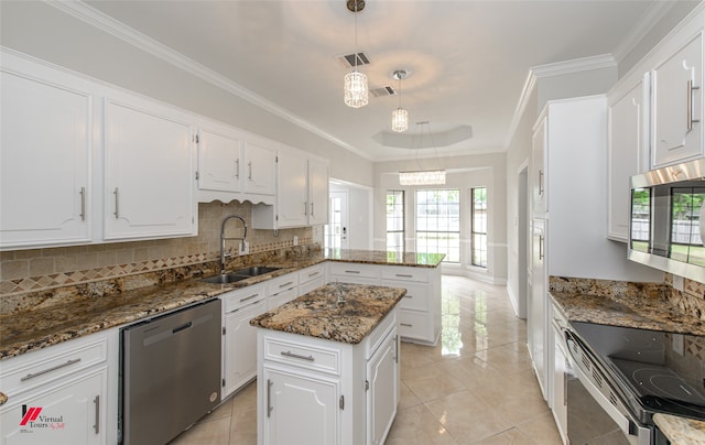 kitchen with white cabinetry, sink, appliances with stainless steel finishes, dark stone countertops, and a kitchen island