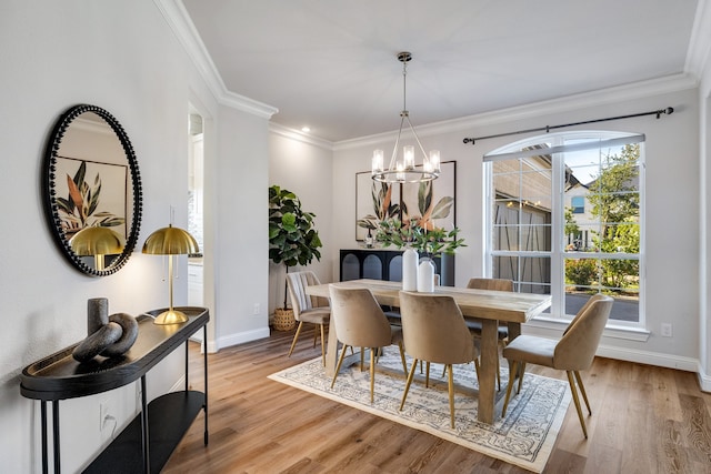 dining area with ornamental molding, light hardwood / wood-style floors, and an inviting chandelier