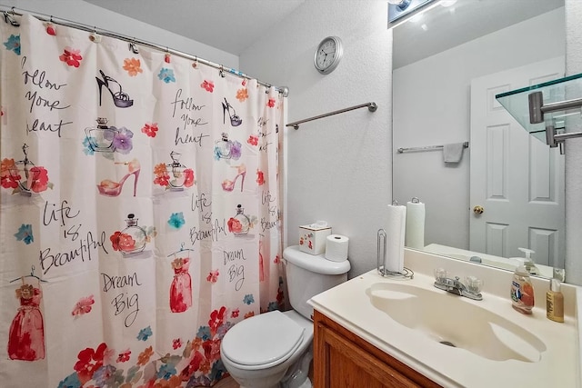 bathroom featuring curtained shower, vanity, and toilet