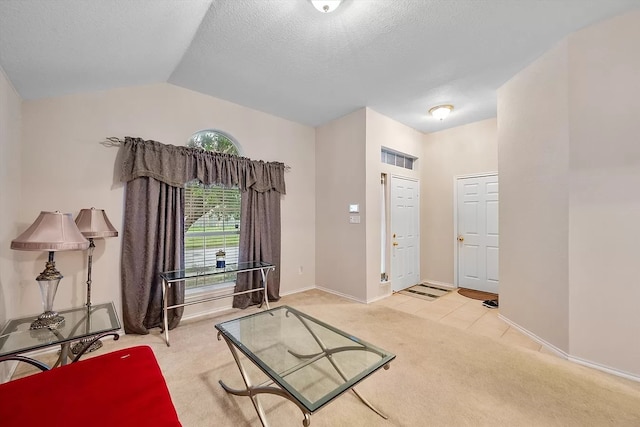 interior space with light colored carpet, lofted ceiling, and a textured ceiling