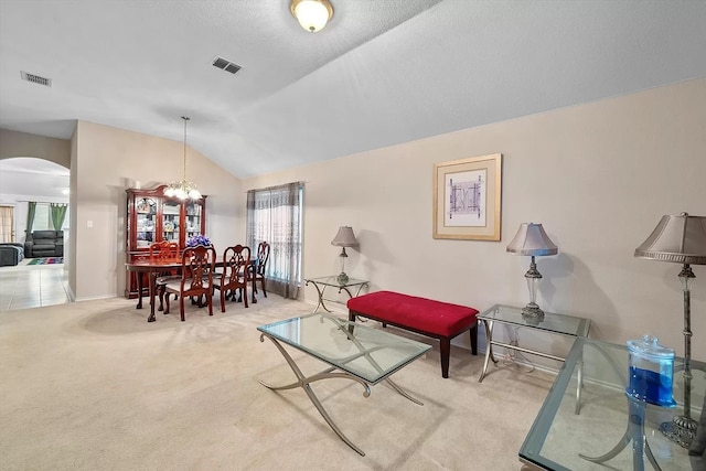 sitting room with carpet flooring, lofted ceiling, and a notable chandelier