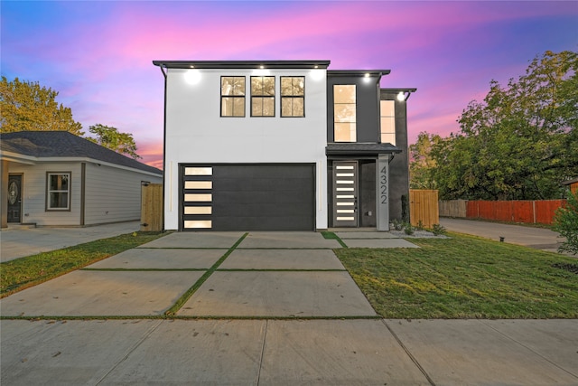 contemporary home with a garage and a lawn