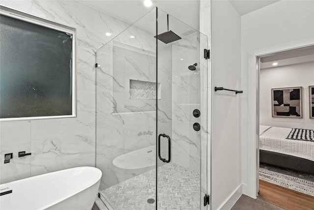 bathroom featuring hardwood / wood-style flooring, plus walk in shower, and tile walls