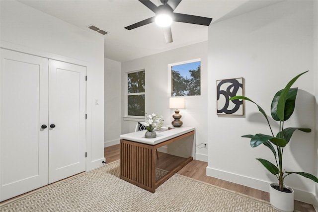 office space with light hardwood / wood-style floors and ceiling fan