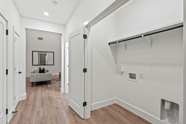 clothes washing area with gas dryer hookup, hookup for a washing machine, and light hardwood / wood-style flooring