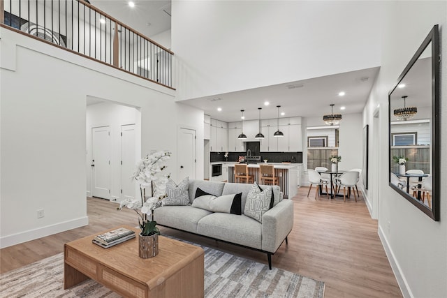 living room featuring light hardwood / wood-style floors and a towering ceiling