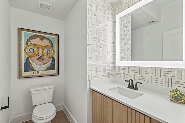 bathroom with toilet, decorative backsplash, vanity, and hardwood / wood-style floors