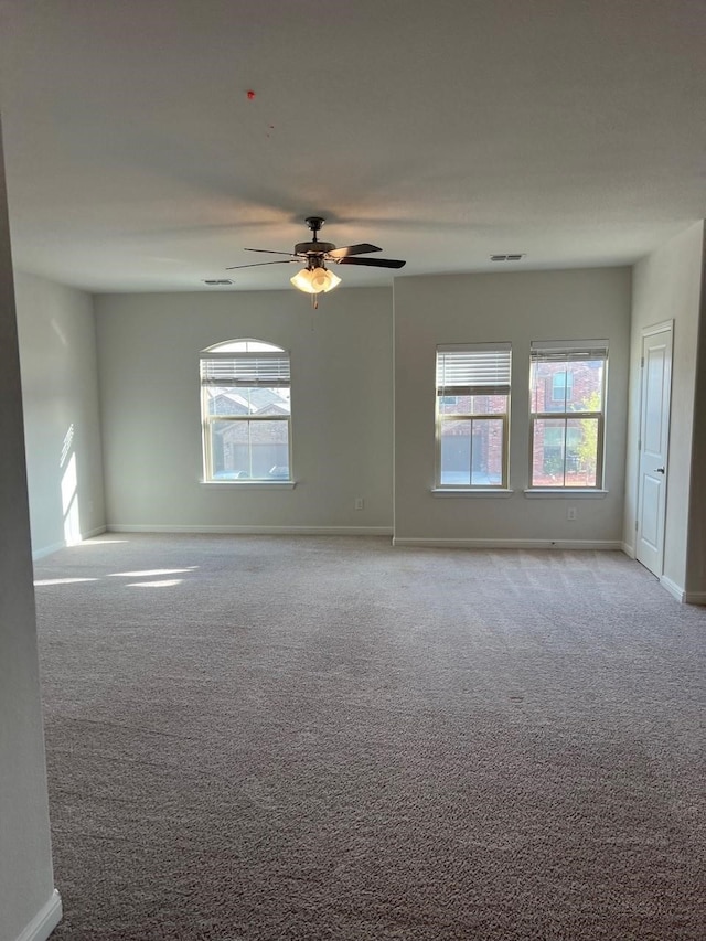 carpeted spare room featuring ceiling fan