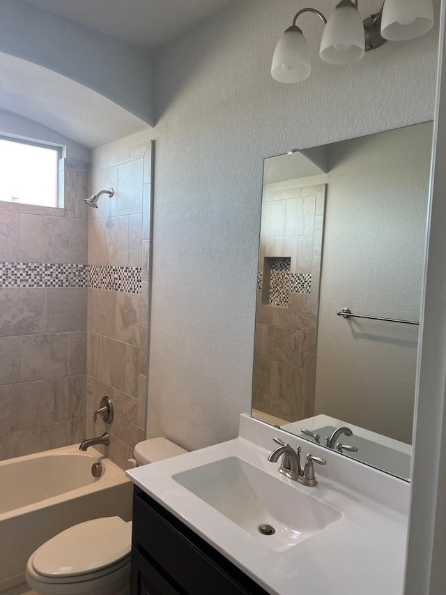 full bathroom with tiled shower / bath, toilet, and vanity