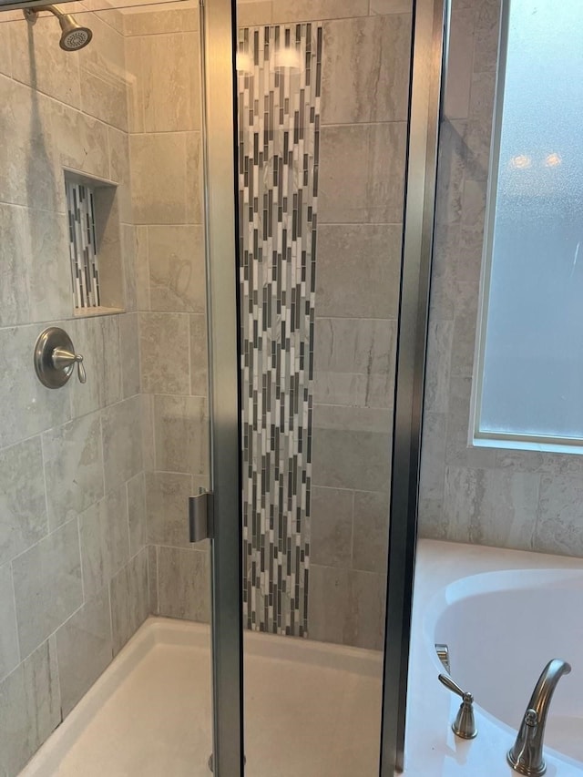 bathroom featuring shower with separate bathtub