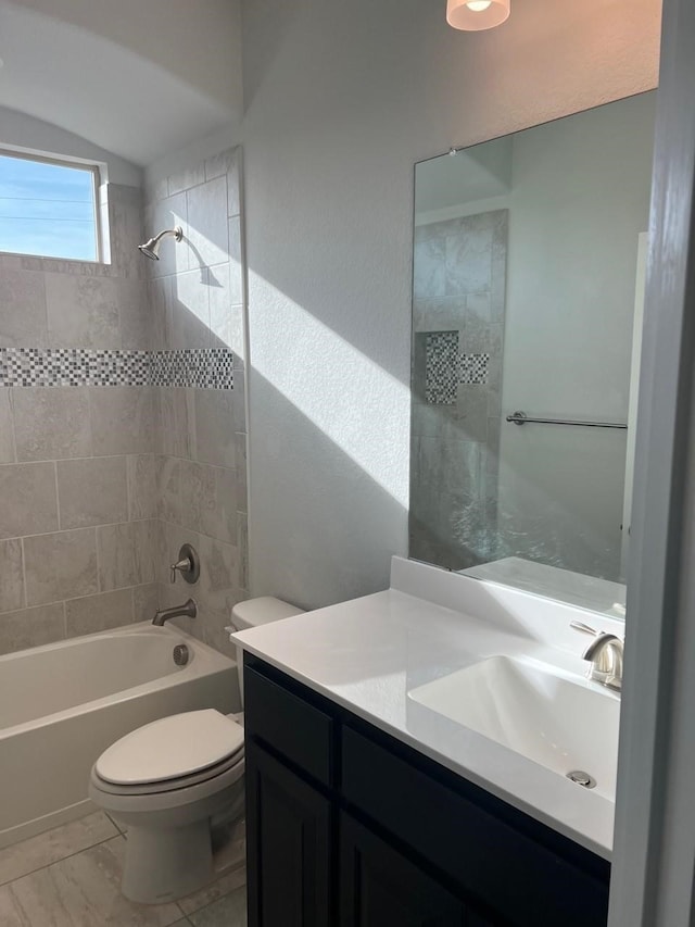 full bathroom with vanity, tile patterned flooring, tiled shower / bath, and toilet