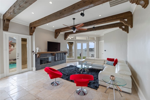 living room with french doors, a tiled fireplace, beamed ceiling, crown molding, and ceiling fan