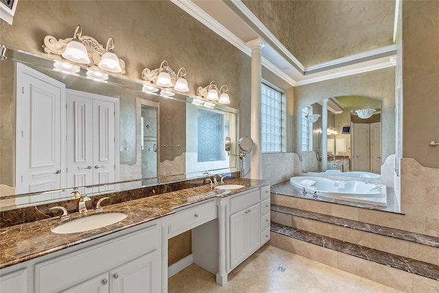 bathroom featuring tile patterned floors, tiled tub, crown molding, vanity, and ornate columns