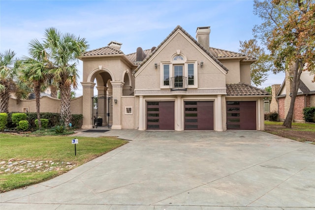 mediterranean / spanish-style house with a garage and a front lawn