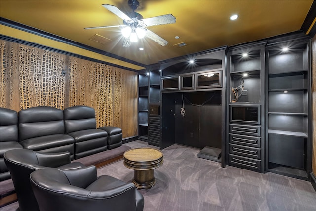 carpeted home theater room with ceiling fan