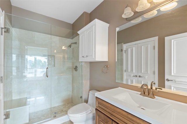 bathroom featuring toilet, vanity, and an enclosed shower