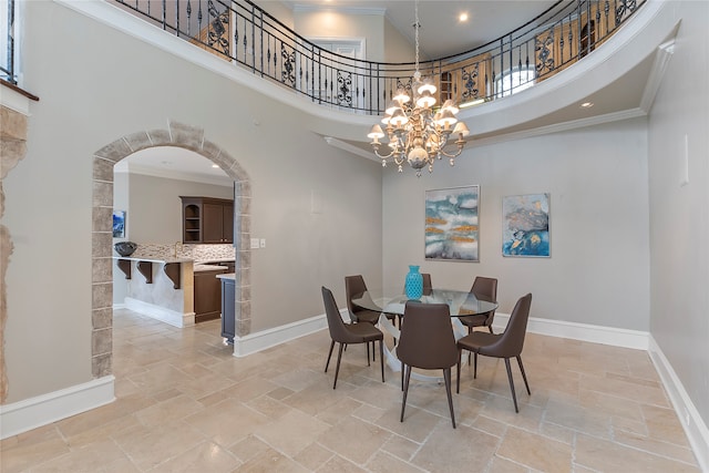 dining room with a high ceiling, an inviting chandelier, and crown molding