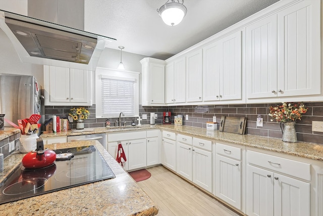 kitchen with white cabinetry, sink, hanging light fixtures, black electric stovetop, and exhaust hood