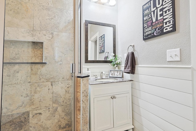 bathroom with vanity, an enclosed shower, and wooden walls