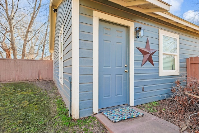 view of exterior entry with a lawn