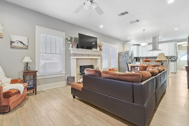 living room with light hardwood / wood-style flooring and ceiling fan