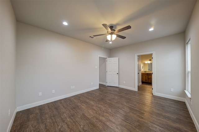 unfurnished bedroom with ceiling fan, ensuite bath, and dark hardwood / wood-style flooring