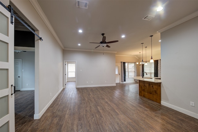 unfurnished living room with ornamental molding, dark wood-type flooring, and a healthy amount of sunlight