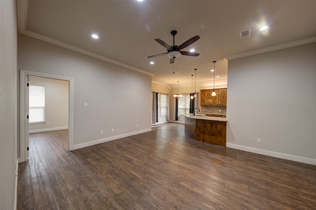 unfurnished living room featuring ceiling fan, dark hardwood / wood-style floors, and ornamental molding