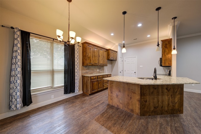 kitchen with sink, kitchen peninsula, light stone countertops, pendant lighting, and dark hardwood / wood-style flooring