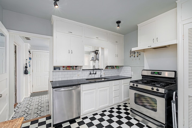 kitchen featuring backsplash, white cabinets, sink, and stainless steel appliances